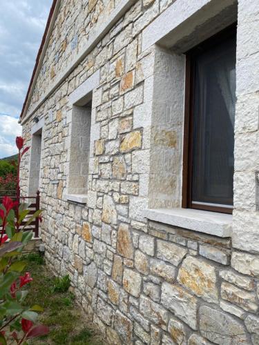 un edificio de piedra con una ventana en el lateral. en Villa Maria 1, en Gliki