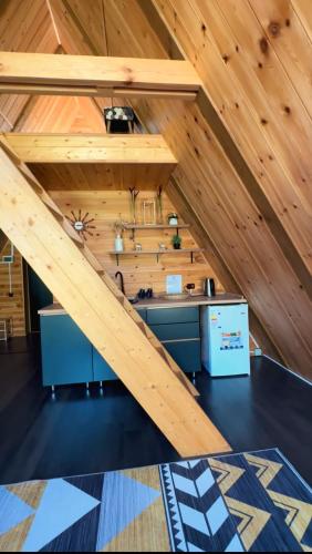 an attic kitchen with wooden walls and a staircase at Turgensai in Taūtürgen