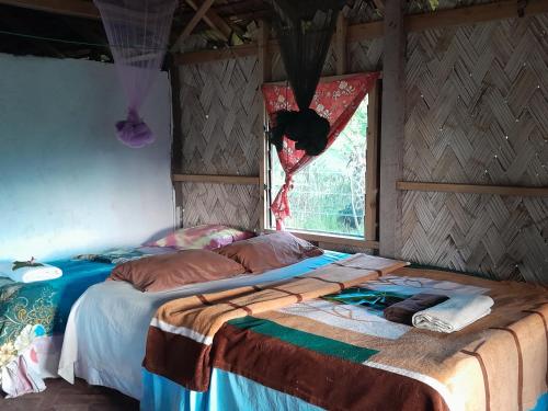 a bedroom with two beds and a window at Yasur View Bungalow and Tree House in White Sands