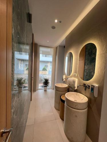 a bathroom with two sinks and a large window at Trevi Hotel & Restorant, Shengjin in Shëngjin