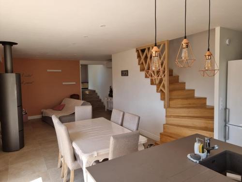 Il comprend une cuisine et un salon avec une table et un escalier. dans l'établissement Maison 3 chambres climatisé + garage, à Roquebrun