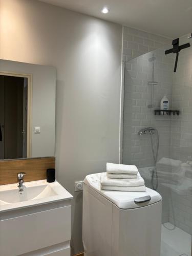 une salle de bain blanche avec un lavabo et une douche dans l'établissement greoux, à Gréoux-les-Bains