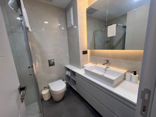 a bathroom with a sink and a toilet and a mirror at Ulu Panorama Residence in Alanya