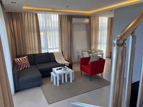 a living room with a couch and a red chair at Ulu Panorama Residence in Alanya