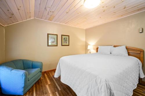 a bedroom with a bed and a blue chair at Carr's Northside Hotel and Cottages in Gatlinburg