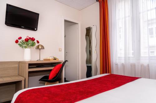 a hotel room with a red bed and a desk at Hotel Elizabeth - Intra Muros in Saint Malo