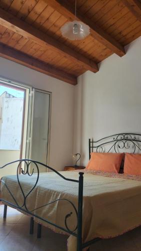 a bedroom with a bed with a wooden ceiling at Casa Rosellina in Cefalù