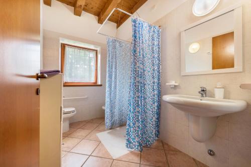 baño con cortina de ducha azul y lavamanos en Bilo Garden Agriturismo Teboi, en Lazise