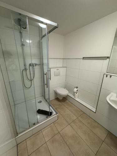 a bathroom with a shower and a toilet and a sink at Pension Zwei A in Leverkusen