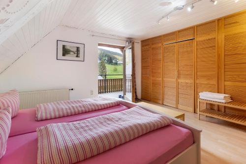 een slaapkamer met een paars bed en een groot raam bij Haus am Südhang in Lenzkirch