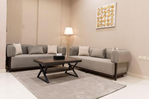 Sala de estar con 2 sofás y mesa de centro en مسكن الحديقة للشقق المخدومة en Riad