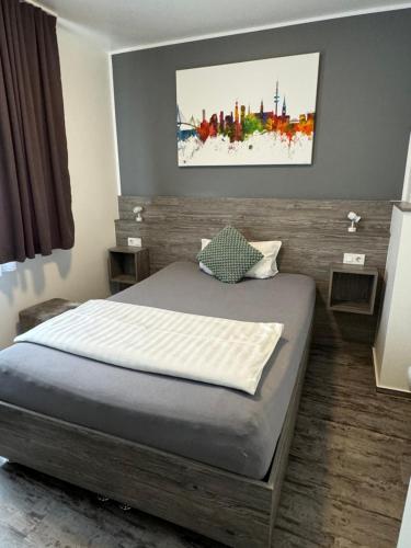 a bedroom with a bed with a painting on the wall at Pension Zwei A in Leverkusen