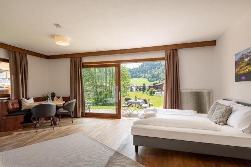 a bedroom with a bed and a desk and a table at Au Pension in Söll