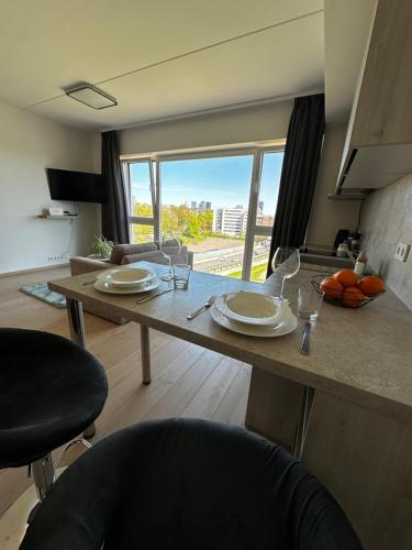 a kitchen with a large wooden table with plates on it at Modern Lux Apartment with Great View in Tallinn