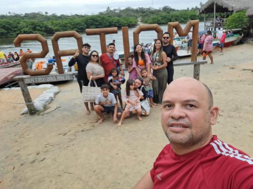 a man standing on the beach with a group of people at Pousada Vela dos Ventos in Praia de Moitas