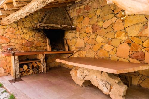 a stone wall with a wooden bench in a room at Los Lebreles Namaste I y II, desconecta en las Hoces del Duratón in Hinojosas del Cerro