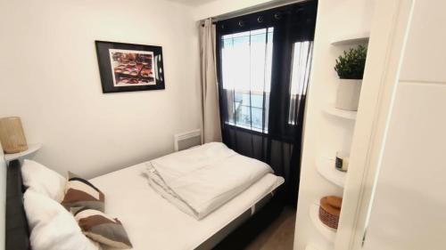 une petite pièce avec un lit et une fenêtre dans l'établissement Dana centre mer 25, à Nice