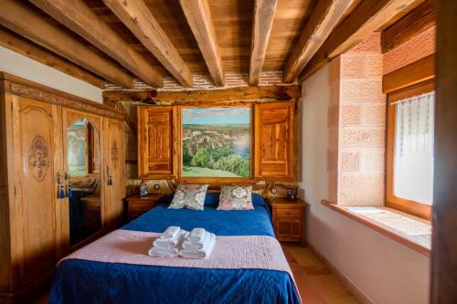 - une chambre avec un lit et des serviettes dans l'établissement Los Lebreles Namaste I y II, desconecta en las Hoces del Duratón, à Hinojosas del Cerro