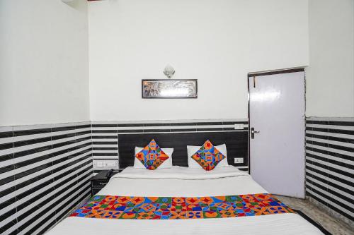 ein Schlafzimmer mit einem großen Bett mit bunten Kissen in der Unterkunft FabHotel Sarwan in Agra