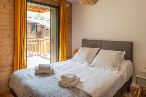 - un lit avec serviettes dans une chambre avec fenêtre dans l'établissement Apartment Cairn Harmony A109, aux Gets