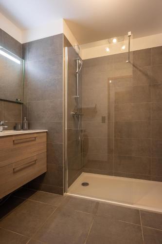 une salle de bain avec une douche avec une porte vitrée dans l'établissement Apartment Cairn Harmony A109, aux Gets