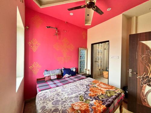 een slaapkamer met een bed met een roze muur bij Hotel Royal Pinkcity in Jaipur