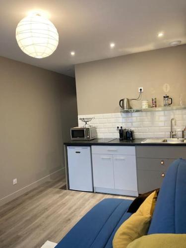 une cuisine avec des armoires blanches et un comptoir dans l'établissement Les Volets bleus, à Honfleur