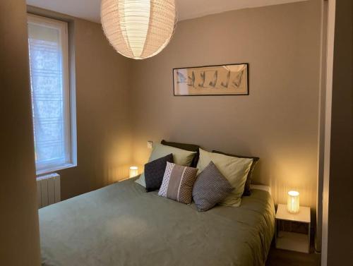 une chambre avec un lit avec des oreillers dessus dans l'établissement Les Volets bleus, à Honfleur