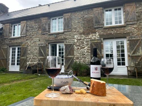 a table with two glasses of red wine and cheese at Le Gîte des Violettes in Ger