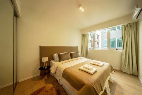 a bedroom with a bed with two towels on it at Fliphaus Be Libertador - Lux 1 Bd 11-21 in Buenos Aires