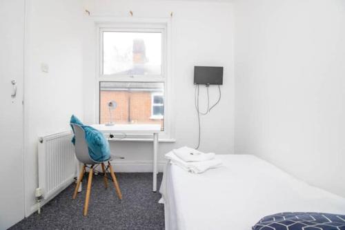a room with a bed and a desk and a window at Pebbles guest house in Southampton