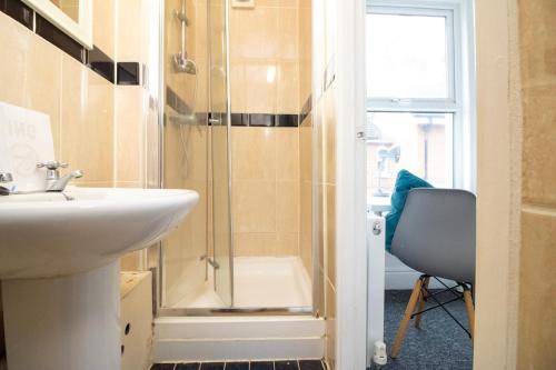 uma casa de banho com um lavatório e um chuveiro em Pebbles guest house em Southampton