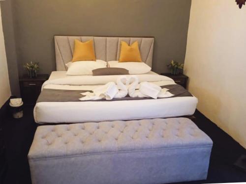 a bedroom with a large bed with a blue ottoman at Silver Ray Hotel in Colombo