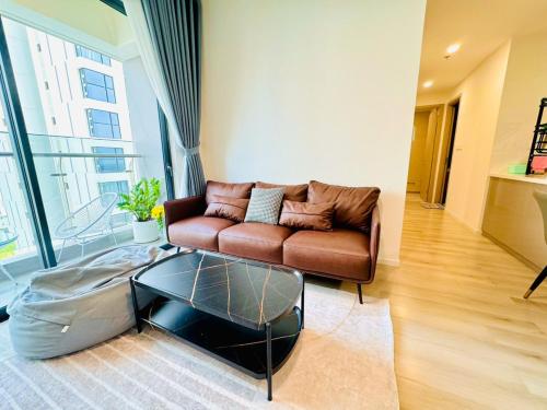 a living room with a couch and a glass coffee table at Luxury Apartment-Vinhomes Grand Park in Gò Công