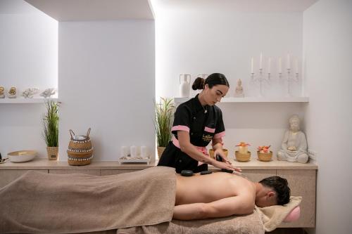 a woman giving a man a massage in a room at Lagon Life Spirit Boutique Hotel - Adults Only in Chania Town