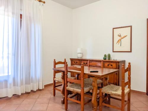 comedor con mesa de madera y sillas en I Fiori di Salici, en Capoliveri