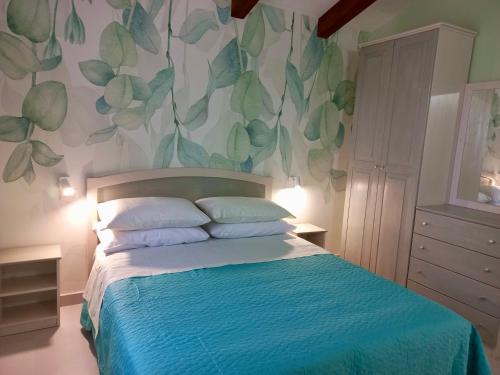 a bedroom with a bed with a blue comforter at Villa Nigro in Laureana Cilento