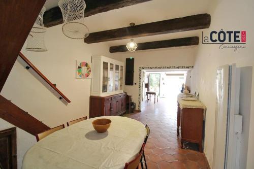 une cuisine et une salle à manger avec une table et des chaises dans l'établissement Jardin Fleuri, à Sausset-les-Pins