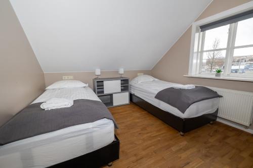 a bedroom with two beds and a window at Bjarnabúð in Húsavík