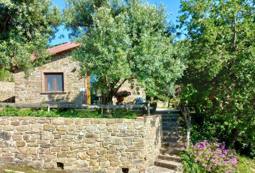 a stone house with a stone wall and trees at Villa Nigro in Laureana Cilento