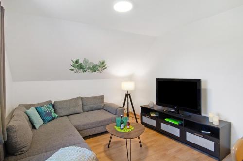 a living room with a couch and a flat screen tv at Ferienwohnung Otte in Apen