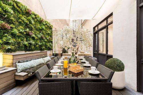 un patio avec une table, des chaises et des plantes dans l'établissement APT 10P 160m2 WITH TERACe, à Paris