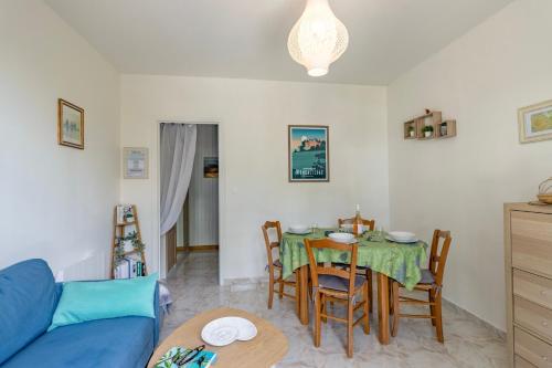 un salon avec une table et un canapé bleu dans l'établissement Au chant des cigales, à Vanxains