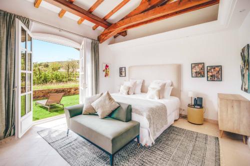 a bedroom with a bed and a chair at Domaine de l'Astragale in Saint-Tropez