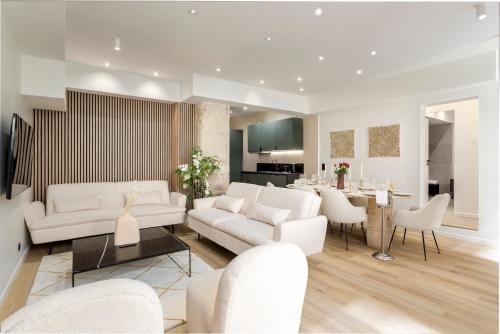Il comprend un salon doté d'un mobilier blanc et une salle à manger. dans l'établissement APT 10P 160m2 WITH TERACe, à Paris
