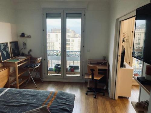 une chambre avec un lit, un bureau et une fenêtre dans l'établissement Lumineux et spacieux à 4 min de Montparnasse, à Malakoff