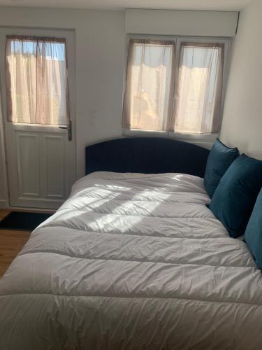 Cette chambre comprend un grand lit et 2 fenêtres. dans l'établissement Studio la voie verte Wi-Fi, télé, à Lorient