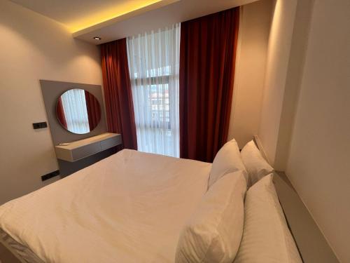 a bedroom with a white bed and a mirror at Ulu Panorama Residence in Alanya