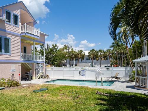 a villa with a swimming pool in front of a house at Lantana Suite in Captiva