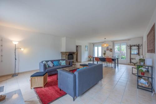 - un salon avec un canapé bleu et un tapis rouge dans l'établissement Le Nest quiet house in city center, à Bayeux